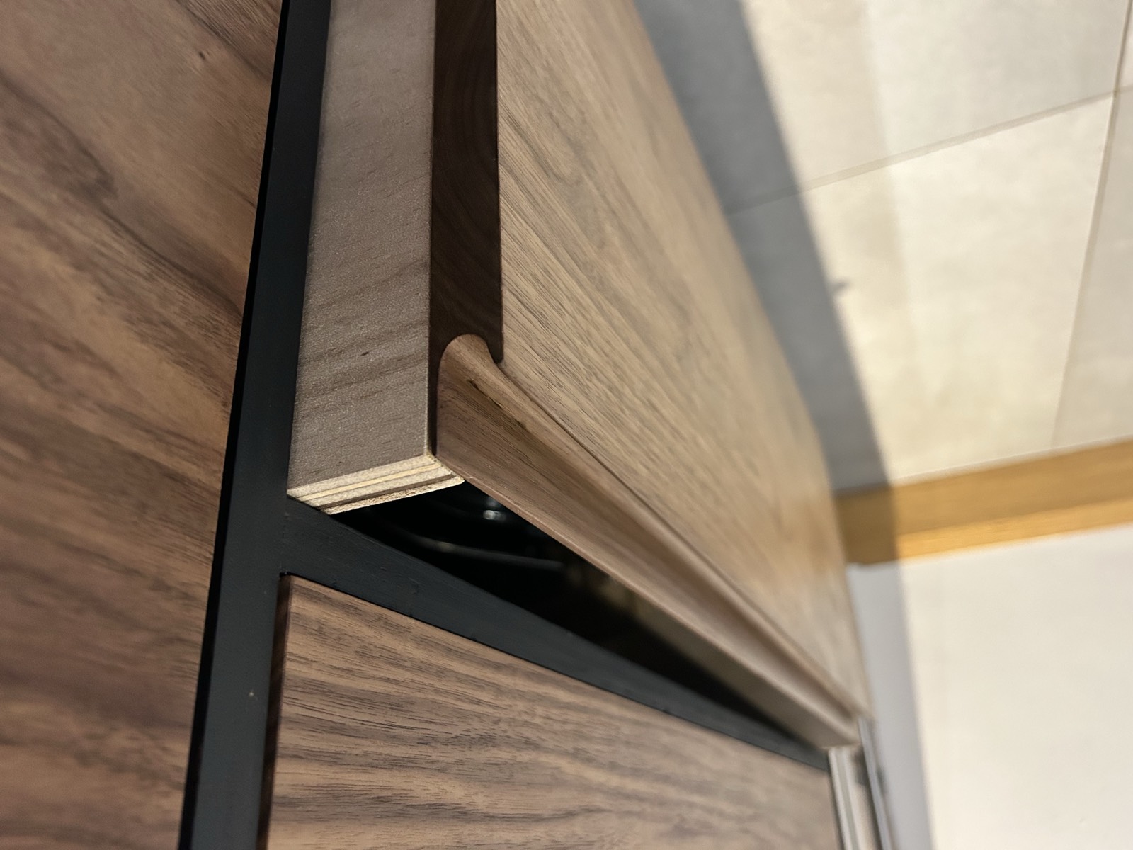Routed pull handle shaped into a solid walnut door edge
