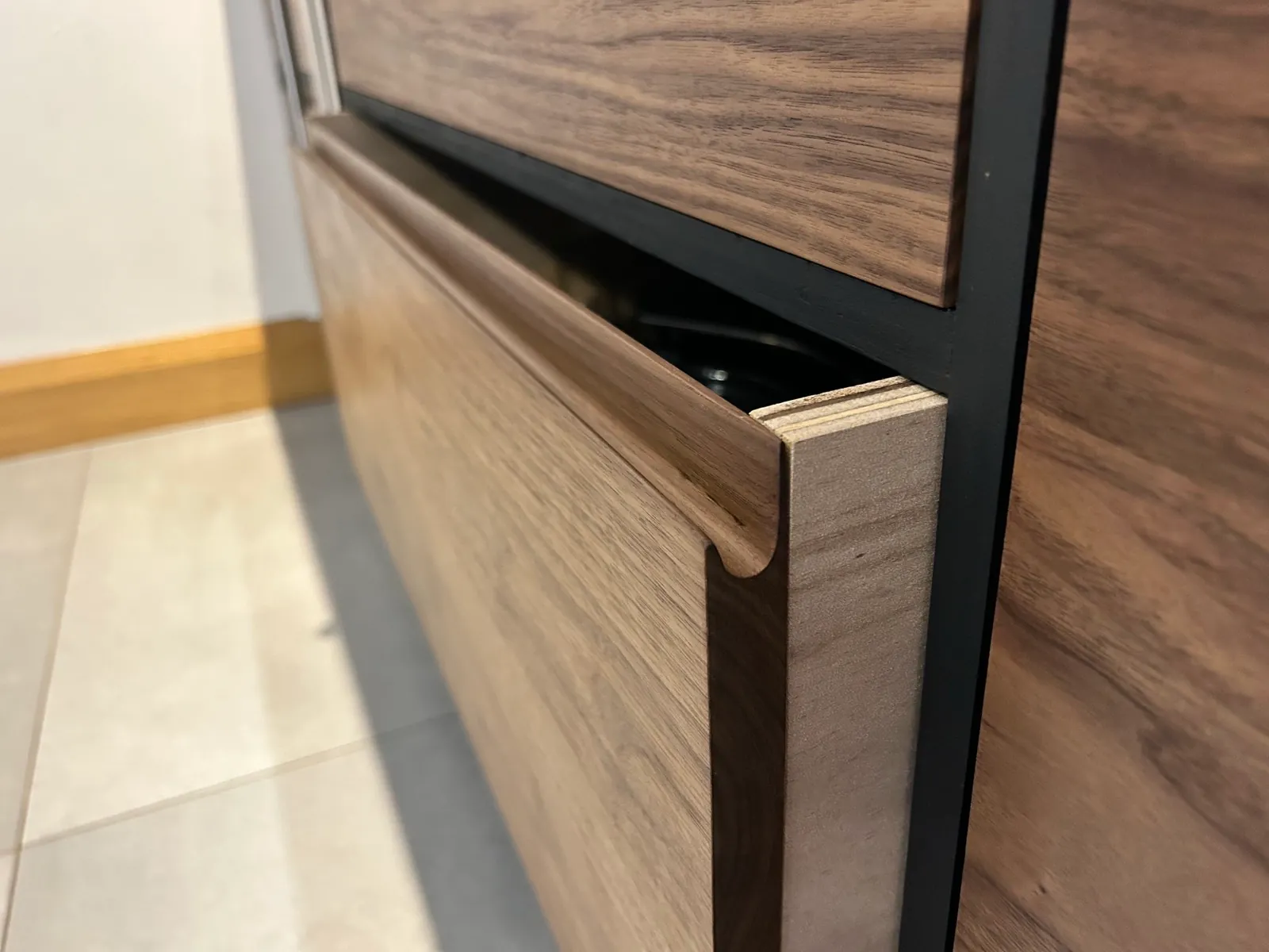 Routed pull handle shaped into a solid walnut door edge