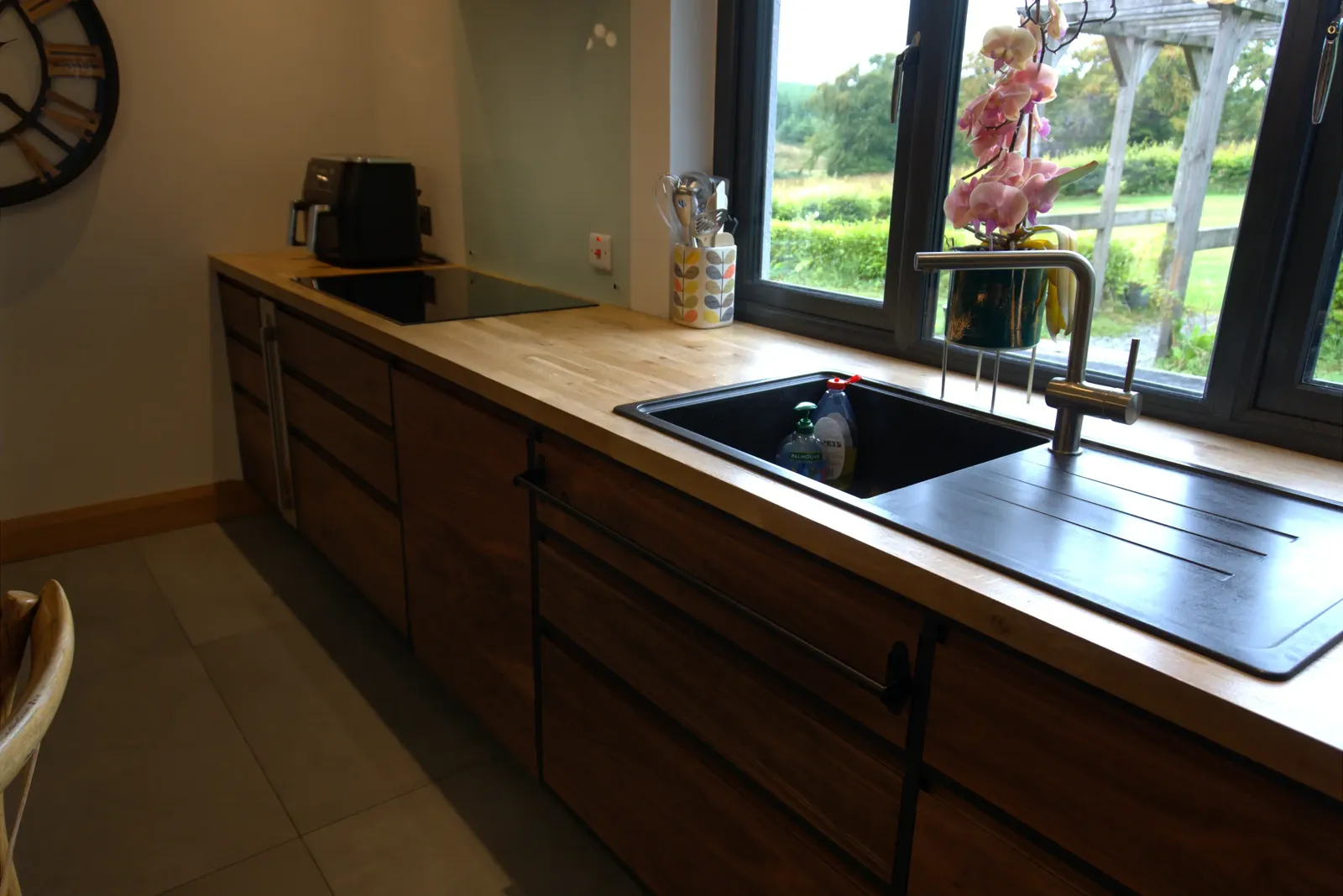 Kitchen sink run under the window with oak worktop and walnut drawer fronts