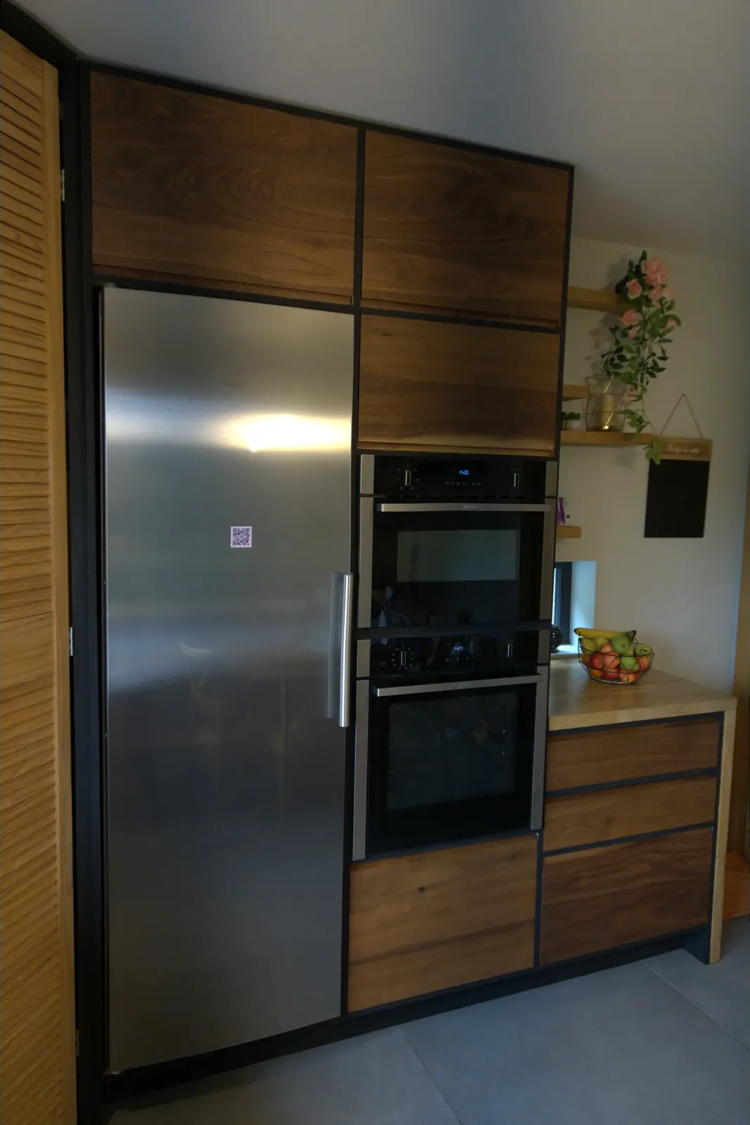Tall walnut units housing the integrated fridge and double oven