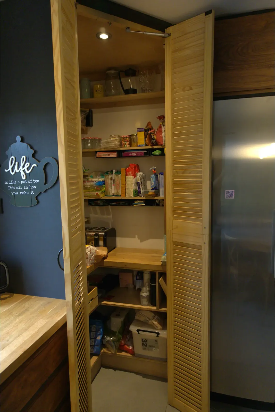 Walk-in corner pantry interior with handmade shelving
